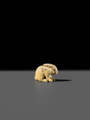 Lot 120 - RANICHI: A FINE IVORY NETSUKE OF A PIEBALD HARE WITH AMBER EYES