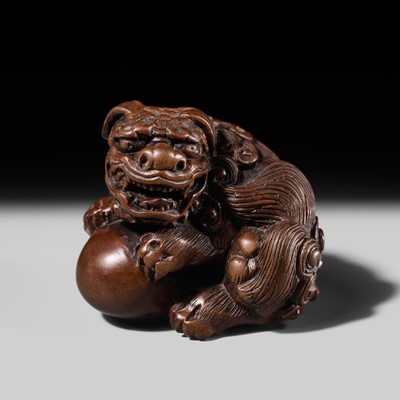 Lot 183 - A FINE WOOD NETSUKE OF A SHISHI WITH BALL, CIRCLE OF TAMETAKA