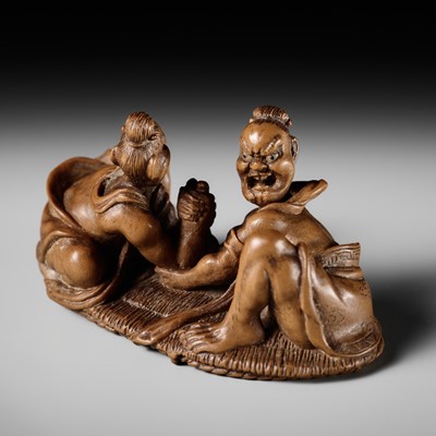 Lot 264 - ITSUMIN: A FINE WOOD NETSUKE OF TWO NIO WRESTLING ON A SANDAL