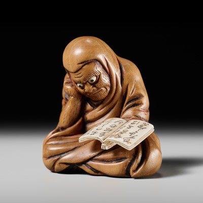 Lot 154 - AN AMUSING INLAID WOOD NETSUKE OF DARUMA READING A BOOK, SHUNGA MITATE, STYLE OF KOKEISAI SANSHO (1871-1926)