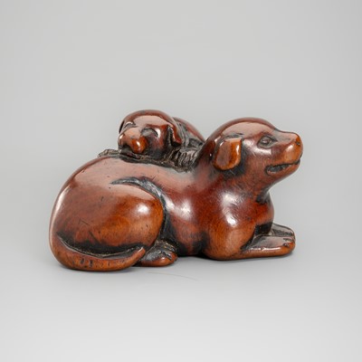 A WOOD NETSUKE OF A DOG AND A PUPPY
