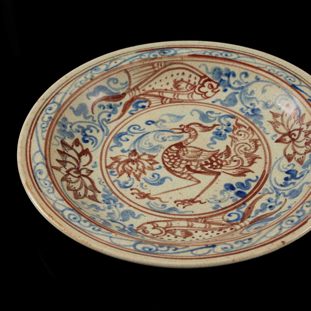 A THAI UNDERGLAZE BLUE AND IRON RED DECORATED STONEWARE DISH