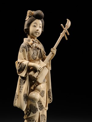 GYOKUSHI: A FINE WALRUS TUSK OKIMONO OF A GEISHA PLAYING A SHAMISEN