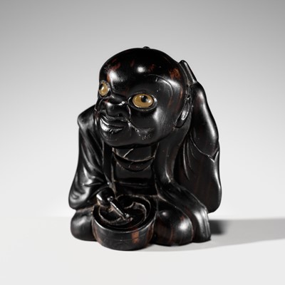 Lot 155 - A HUMOROUS KUROGAKI WOOD NETSUKE OF FUKUSUKE