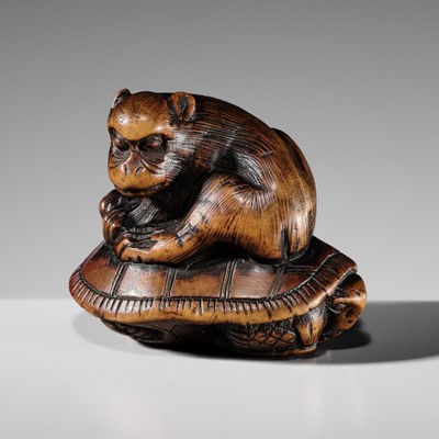 A WOOD NETSUKE OF A MONKEY ATOP A TORTOISE
