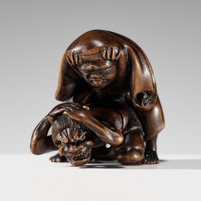 Lot 259 - HOSHUNSAI MASAYUKI: A FINE WOOD NETSUKE OF A MAN DISGUISED AS A BAKEMONO FRIGHTENING AN ONI