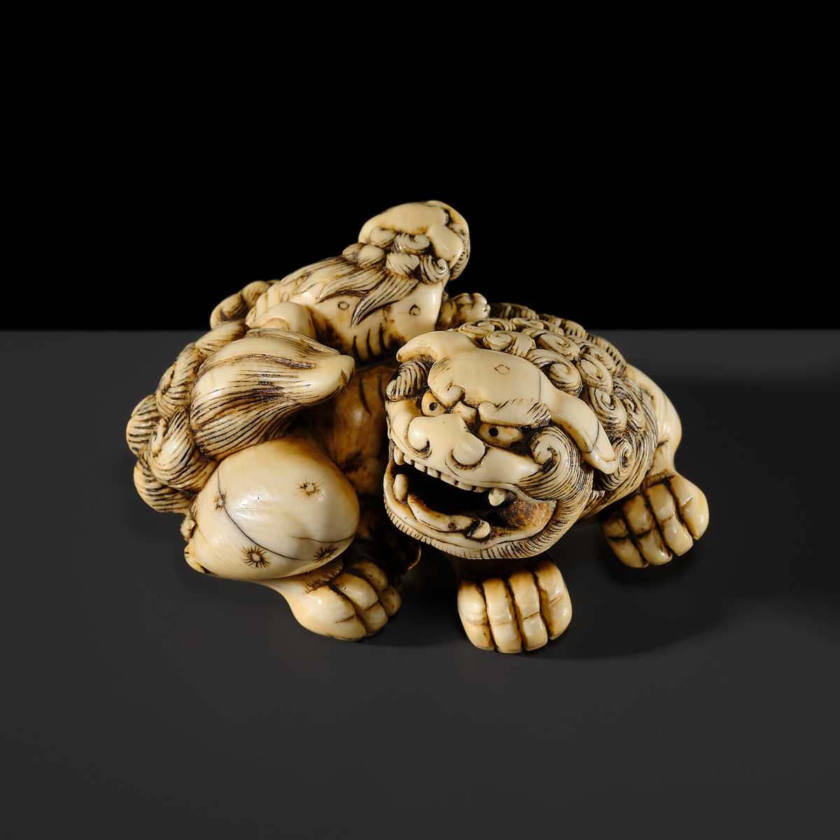 Lot 104 - A LARGE IVORY NETSUKE OF A SHISHI AND ITS YOUNG