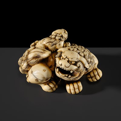 Lot 104 - A LARGE IVORY NETSUKE OF A SHISHI AND ITS YOUNG