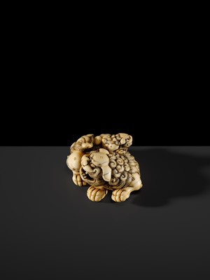 Lot 104 - A LARGE IVORY NETSUKE OF A SHISHI AND ITS YOUNG