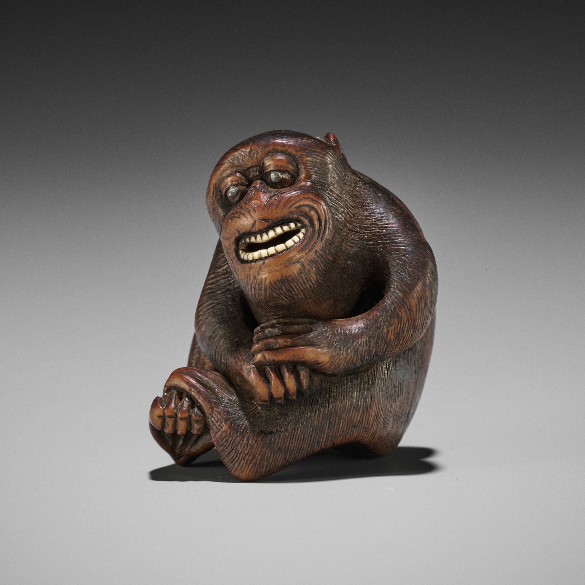 Lot 367 - A HUMOROUS WOOD NETSUKE OF A SMILING MONKEY,