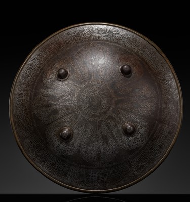 Lot 580 - A QAJAR SILVER INLAID AND DAMASCENED STEEL SHIELD, SIPAR, 18TH-19TH CENTURY