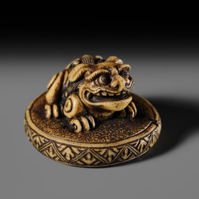 A FINE ANTLER NETSUKE OF A SHISHI ON A CUSHION, ATTRIBUTED TO RENSAI