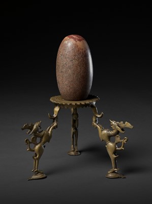 Lot 748 - AN INDIAN STONE BRAHMANDA, ‘COSMIC EGG’, AND MATCHING BRONZE TRIPOD STAND