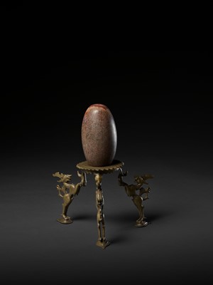 Lot 748 - AN INDIAN STONE BRAHMANDA, ‘COSMIC EGG’, AND MATCHING BRONZE TRIPOD STAND