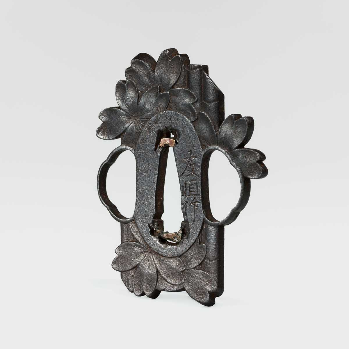 Lot 59 - NAKAI TOMOTSUNE: A RARE CHOSHU SCHOOL IRON TSUBA WITH SAKURA AND BAMBOO