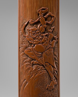 RYU: A CARVED BAMBOO WRIST REST DEPICTING AN ONI WITH BRUSH