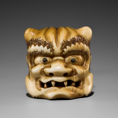 A FINE STAINED IVORY NETSUKE OF AN ONI HEAD