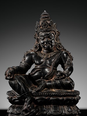 Lot 20 - A FINELY CARVED BLACK STONE FIGURE OF JAMBHALA, TIBET, 15TH-17TH CENTURY