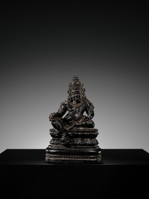 Lot 20 - A FINELY CARVED BLACK STONE FIGURE OF JAMBHALA, TIBET, 15TH-17TH CENTURY