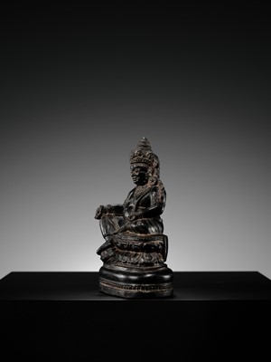 Lot 20 - A FINELY CARVED BLACK STONE FIGURE OF JAMBHALA, TIBET, 15TH-17TH CENTURY