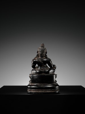 Lot 20 - A FINELY CARVED BLACK STONE FIGURE OF JAMBHALA, TIBET, 15TH-17TH CENTURY