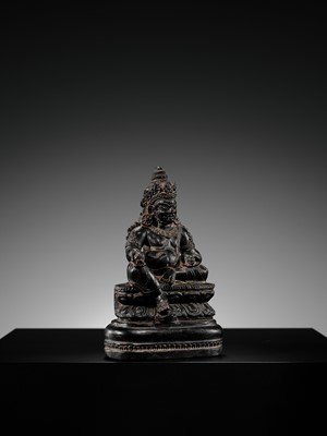 Lot 20 - A FINELY CARVED BLACK STONE FIGURE OF JAMBHALA, TIBET, 15TH-17TH CENTURY