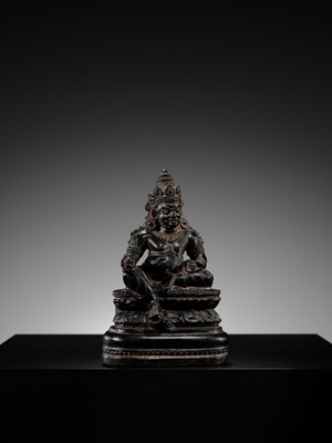 Lot 20 - A FINELY CARVED BLACK STONE FIGURE OF JAMBHALA, TIBET, 15TH-17TH CENTURY