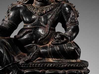 Lot 20 - A FINELY CARVED BLACK STONE FIGURE OF JAMBHALA, TIBET, 15TH-17TH CENTURY