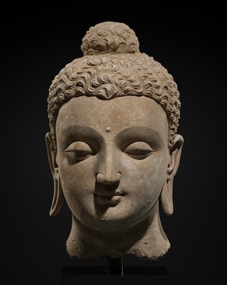 Lot 235 - A MAGNIFICENTLY MODELED OVER-LIFESIZE STUCCO HEAD OF BUDDHA, ANCIENT REGION OF GANDHARA, 3RD TO 4TH CENTURY