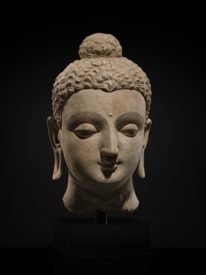 Lot 235 - A MAGNIFICENTLY MODELED OVER-LIFESIZE STUCCO HEAD OF BUDDHA, ANCIENT REGION OF GANDHARA, 3RD TO 4TH CENTURY