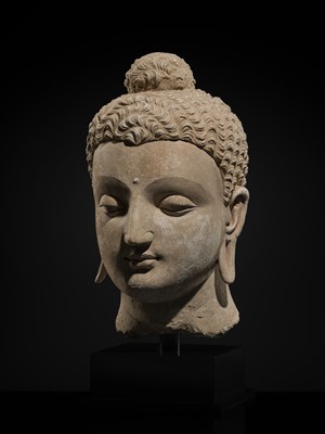 Lot 235 - A MAGNIFICENTLY MODELED OVER-LIFESIZE STUCCO HEAD OF BUDDHA, ANCIENT REGION OF GANDHARA, 3RD TO 4TH CENTURY