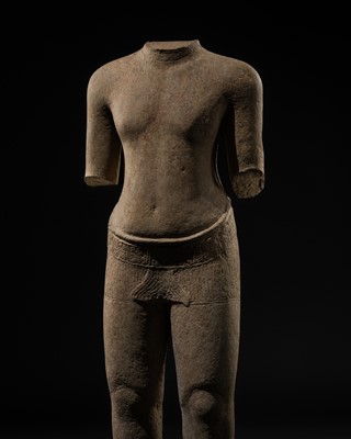 Lot 410 - A BUFF SANDSTONE FIGURE OF A MALE ATTENDANT, ANGKOR PERIOD, BAYON STYLE, 12TH-13TH CENTURY