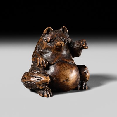 AN UNUSUAL ITTOBORI WOOD NETSUKE OF TANUKI HARA NO TSUZUMI