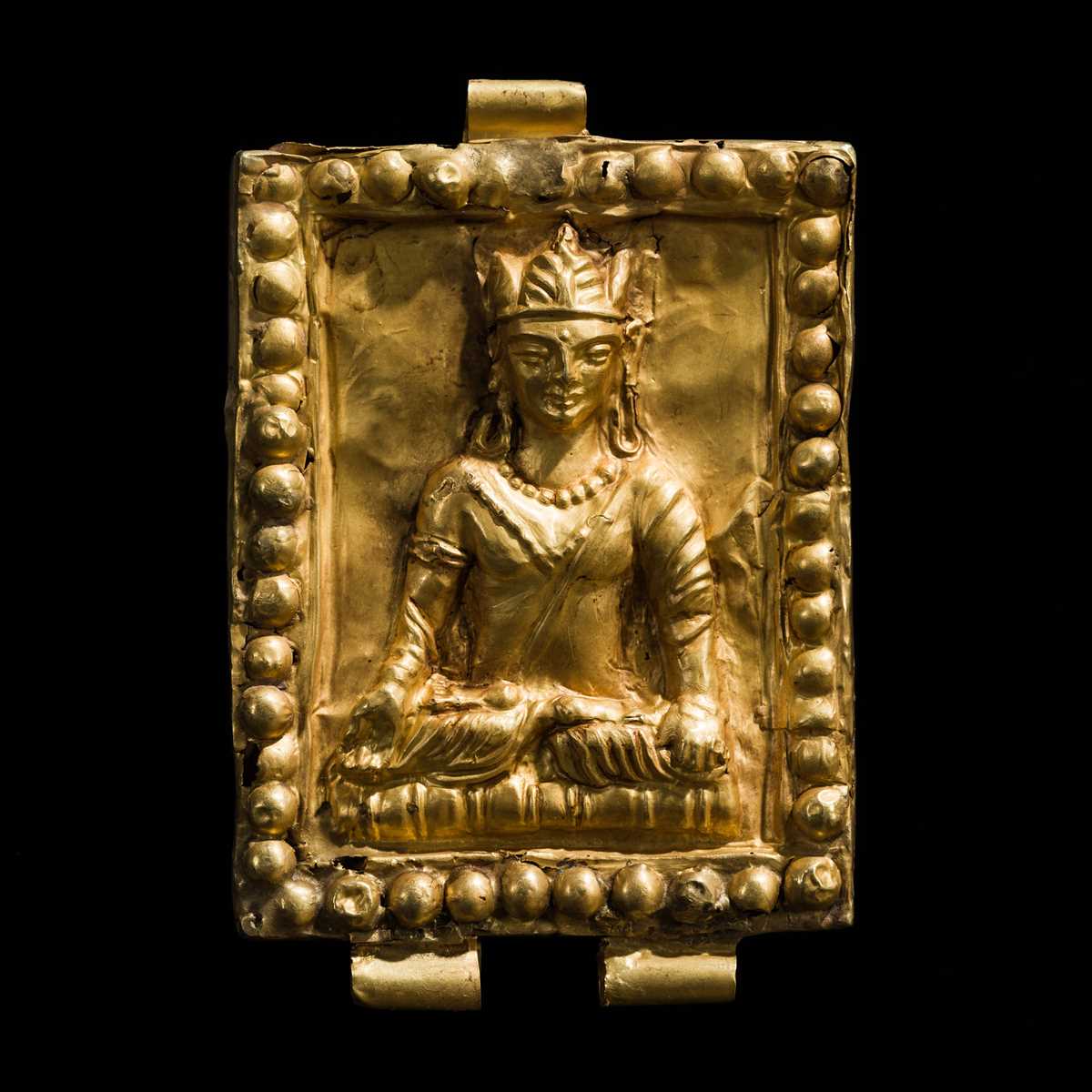 Lot 574 - A GOLD REPOUSSÉ ‘CROWNED BUDDHA’ PENDANT,