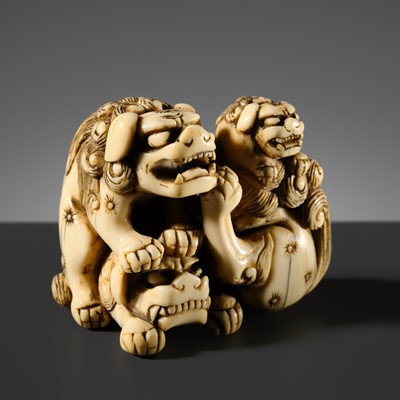 Lot 436 - AN OLD IVORY NETSUKE OF A GROUP OF SHISHI