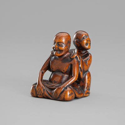 A WOOD NETSUKE OF A BLIND MASSEUR AND CLIENT