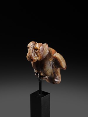 Lot 82 - AN AGATE AMULET IN THE FORM OF A LION-HEADED EAGLE, IMDUGUD, WESTERN ASIA, CIRCA THIRD MILLENNIUM BC