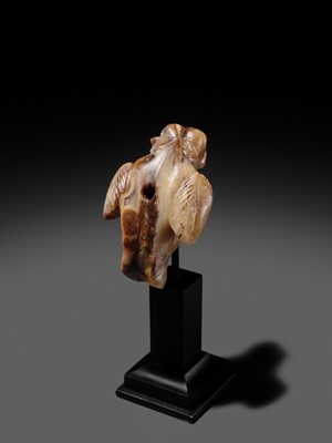 Lot 82 - AN AGATE AMULET IN THE FORM OF A LION-HEADED EAGLE, IMDUGUD, WESTERN ASIA, CIRCA THIRD MILLENNIUM BC