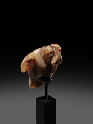 Lot 82 - AN AGATE AMULET IN THE FORM OF A LION-HEADED EAGLE, IMDUGUD, WESTERN ASIA, CIRCA THIRD MILLENNIUM BC