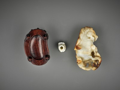 Lot 67 - A RUSSET AND WHITE JADE ‘BUDDHIST LION’ WATER POT AND COVER WITH MATCHING HARDWOOD BASE, LATE MING TO EARLY QING