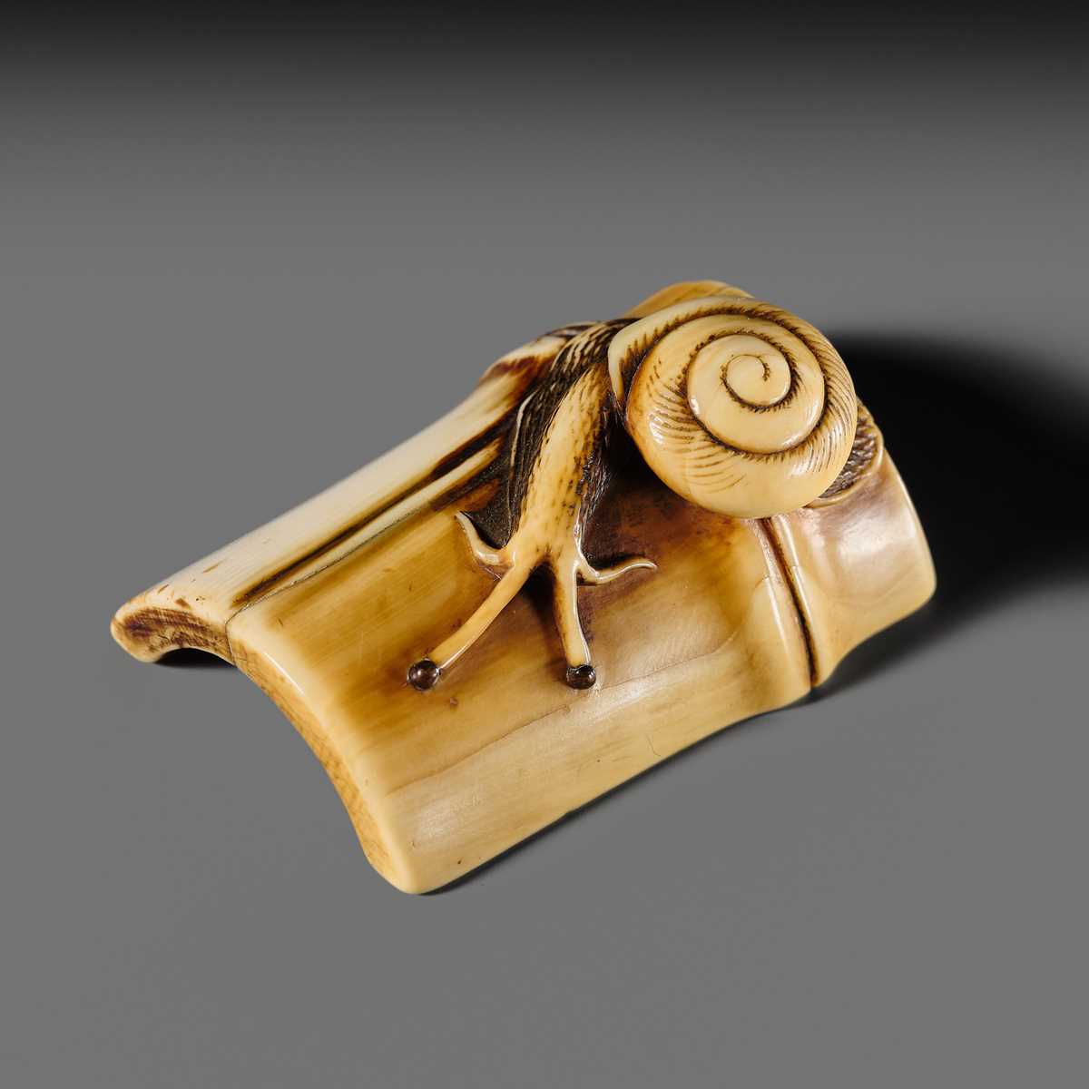 Lot 140 - HIDEMASA: A FINE OSAKA SCHOOL IVORY NETSUKE OF A SNAIL ON BAMBOO