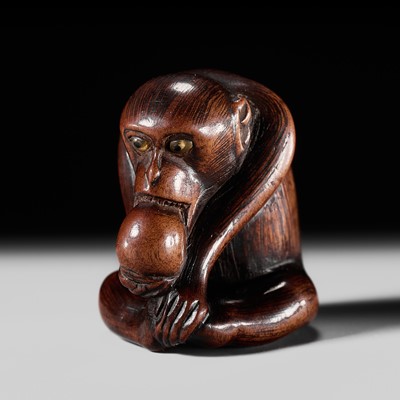 Lot 196 - A FINE WOOD NETSUKE OF A MONKEY EATING A PERSIMMON, SCHOOL OF KANO TOMOKAZU