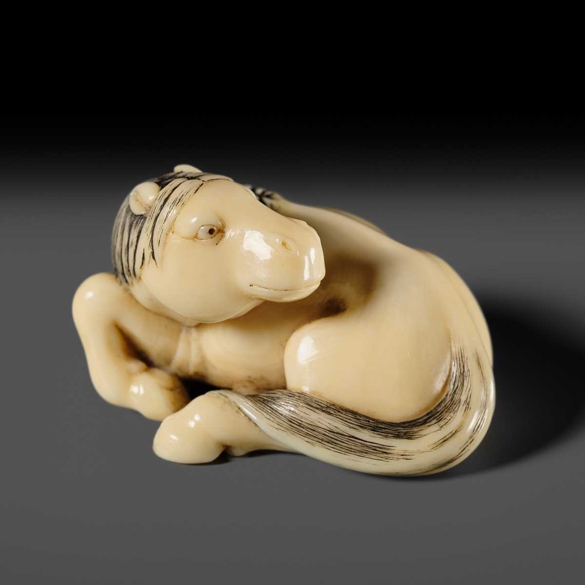 Lot 111 - JOEI: A SUPERB MARINE IVORY NETSUKE OF A RECLINING HORSE