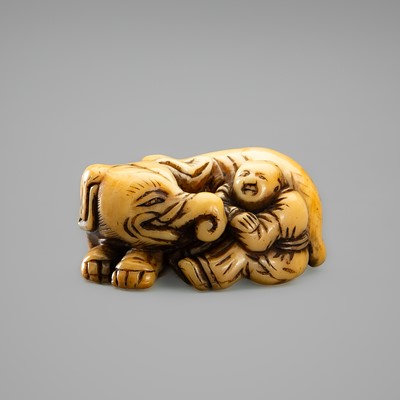 AN IVORY NETSUKE OF A BOY WITH AN ELEPHANT