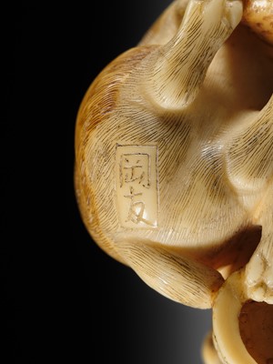 Lot 121 - OKATOMO: A CHARMING IVORY NETSUKE OF TWO PUPPIES WITH AWABI