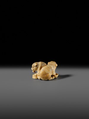 Lot 121 - OKATOMO: A CHARMING IVORY NETSUKE OF TWO PUPPIES WITH AWABI