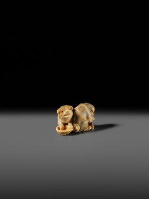 Lot 121 - OKATOMO: A CHARMING IVORY NETSUKE OF TWO PUPPIES WITH AWABI