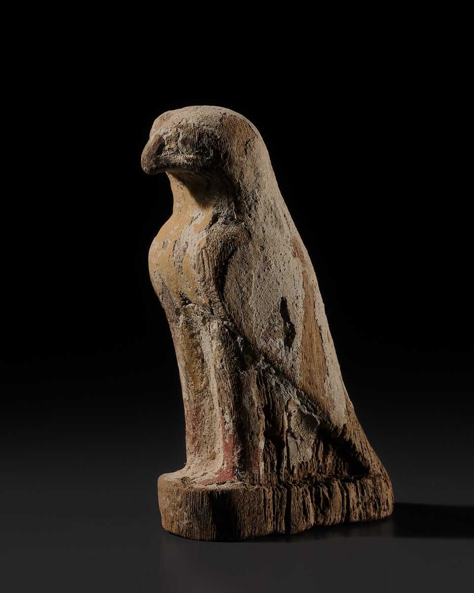 Lot 18 - A PAINTED WOOD FIGURE OF A FALCON, THE EMBODIMENT OF HORUS, LATE PERIOD TO PTOLEMAIC ERA