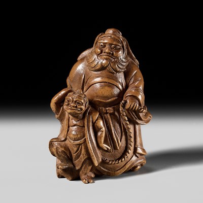 Lot 480 - KISEN: A RARE AND AMUSING WOOD ‘SHOKI WITH LEASHED ONI’ NETSUKE