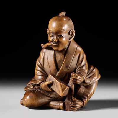 Lot 158 - SUKEKAZU: A FINE WOOD NETSUKE OF A MAN SMOKING A PIPE AND SHARPENING A KAMA